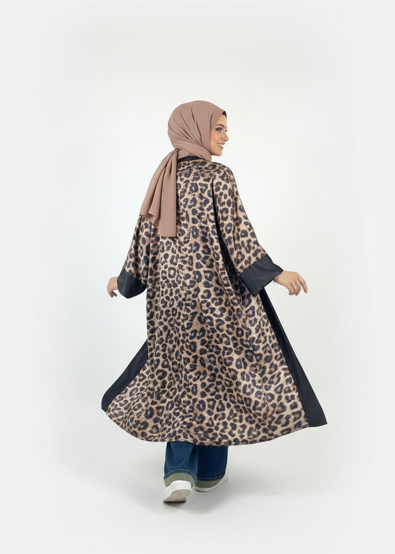 Woman wearing a leopard print dress with black trim on a white background